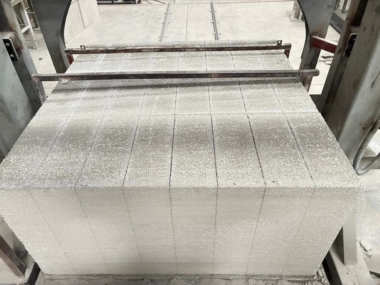 Bloques de concreto celular aligerado recién cortados en la línea de producción.